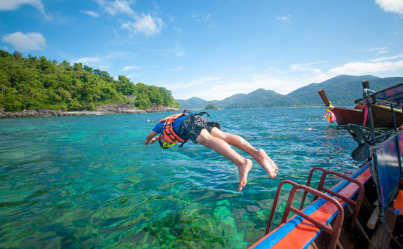 men diving off boat