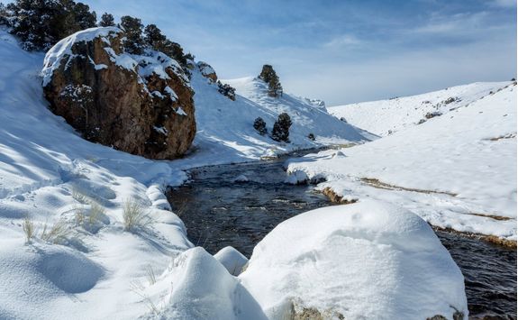 snow covered rock and river