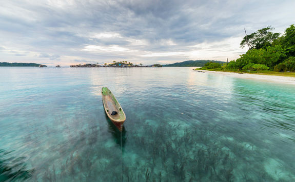 traditional canoe floating at sunset