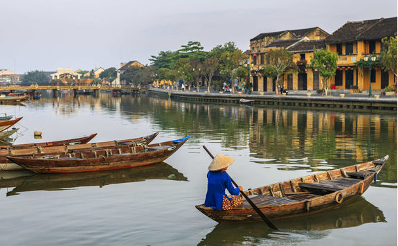 Vietnamese woman padding in old town in Hoi An