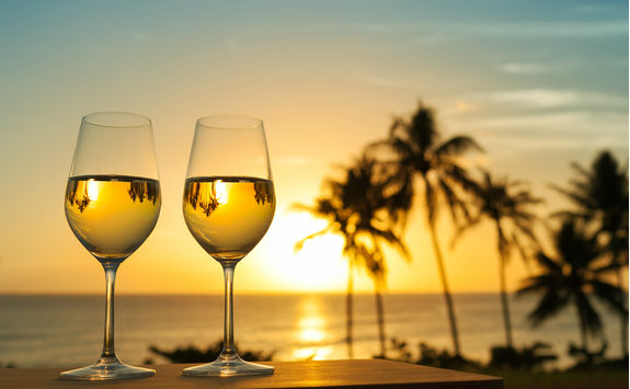White wine glasses on a sunset beach