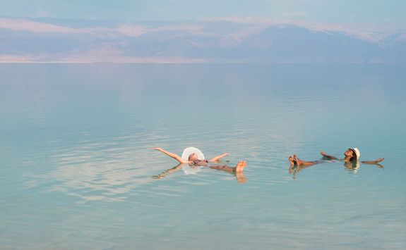 women floating in dead sea