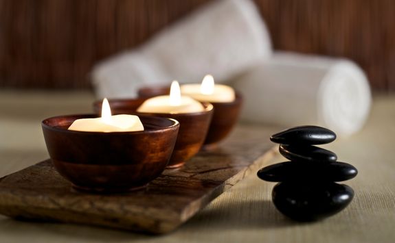 lit candles and black massage stones