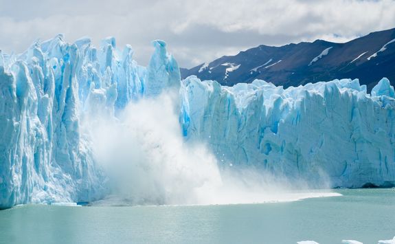 breaking ice falling from glacier
