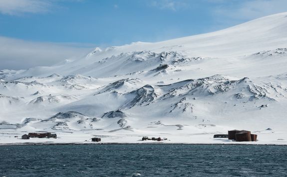 abandoned whaling station with snowy mountain in the background