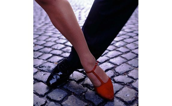 closeup of tango dancers foot step on pebble stone street