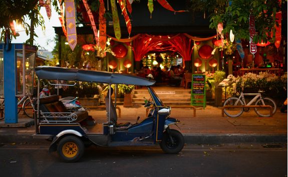 tuk tuk parked in front of a restaurant