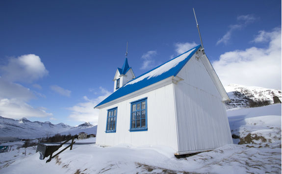 Blue church on Iceland in winter covered with snow
