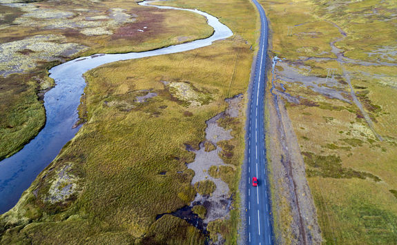 Aerial view of red car driving on road in Iceland