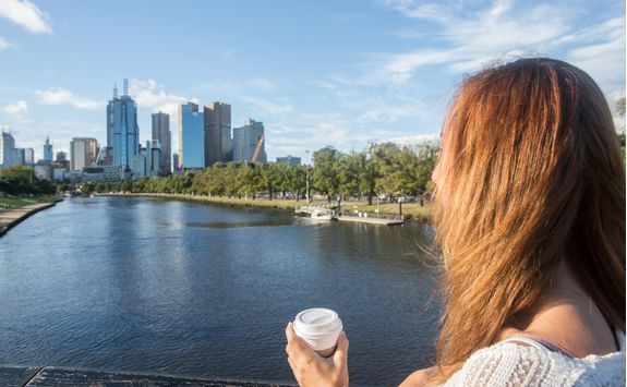 Woman on bridge overlooks Melbourne