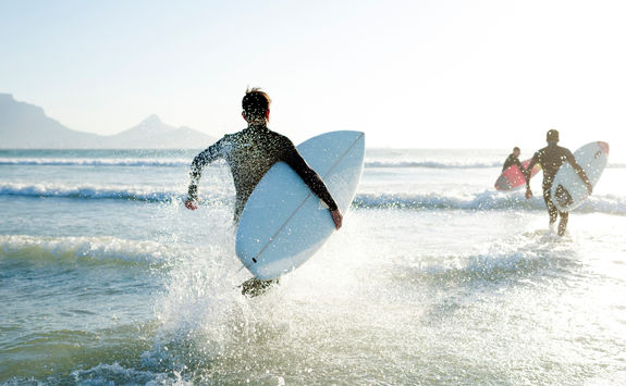 surfers running to sea