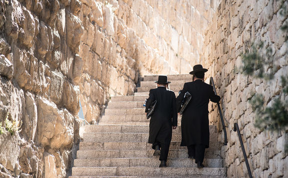 Two men walking up stairs in Jerusalem wearing Jewish Orthodox clothing