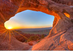 Sun rising through an arch