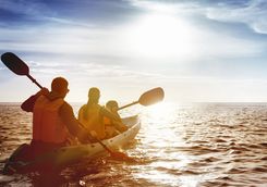 Family kayaking at sunset