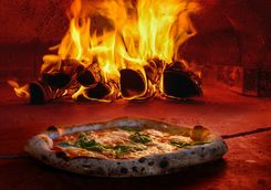 cooking pizza in a pizza oven
