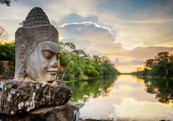 Stone face Asura and sunset over Angkor Thom