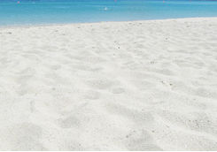 Sandy beach and boats in the water in Mykonos