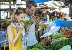 Couple smelling vegetables in a street market