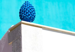ceramic blue pine cone against turquoise wall
