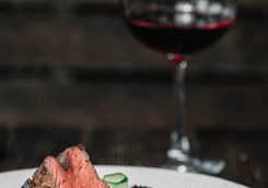 grilled beefsteak with glass of red wine on dark wooden background