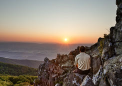 Man watches the sunrise over the Blue Ridge
