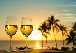 White wine glasses on a sunset beach