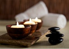 lit candles and black massage stones