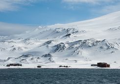abandoned whaling station with snowy mountain in the background
