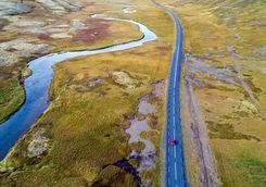 Aerial view of a red car driving on road