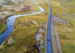 Aerial view of red car driving on road in Iceland