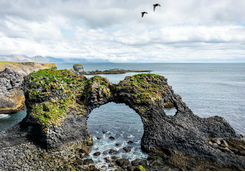 Gatklettur arch rock with two birds fly