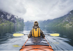 Woman kayaking in fjord in Norway