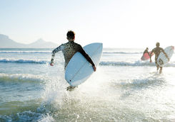 surfers running to sea