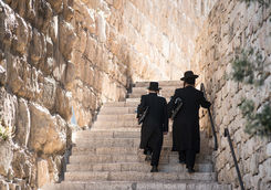 Two men walking up stairs in Jerusalem wearing Jewish Orthodox clothing