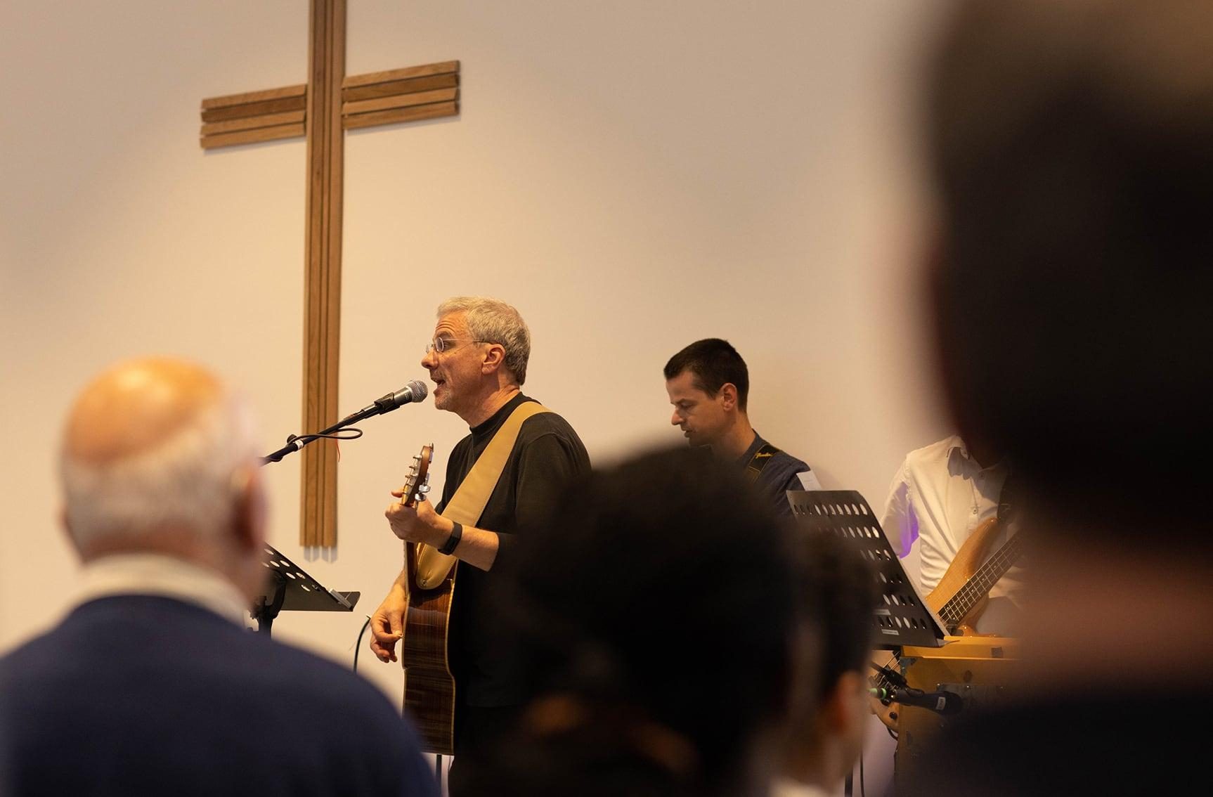 Person leading worship in front cross