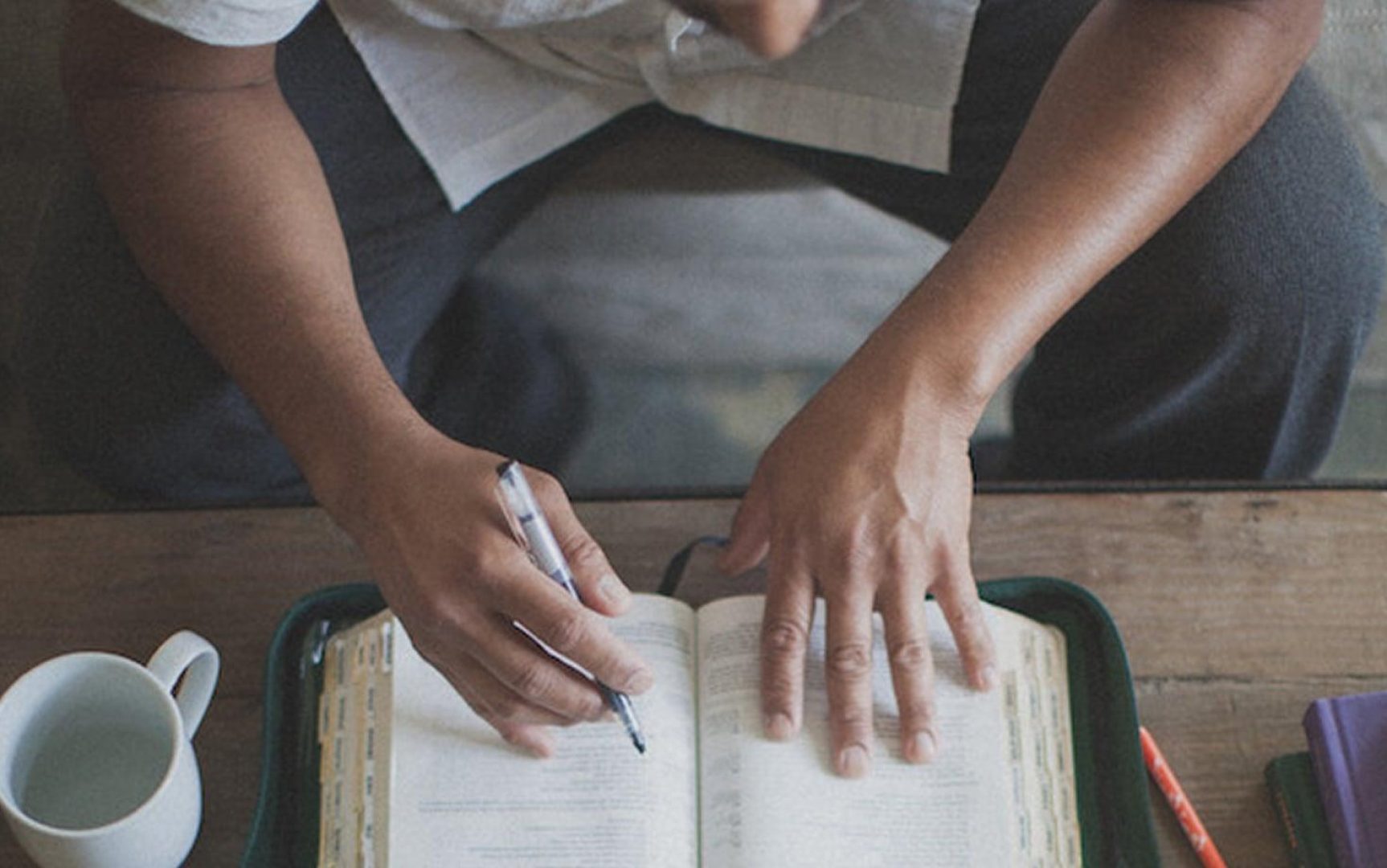 Person taking notes from bible