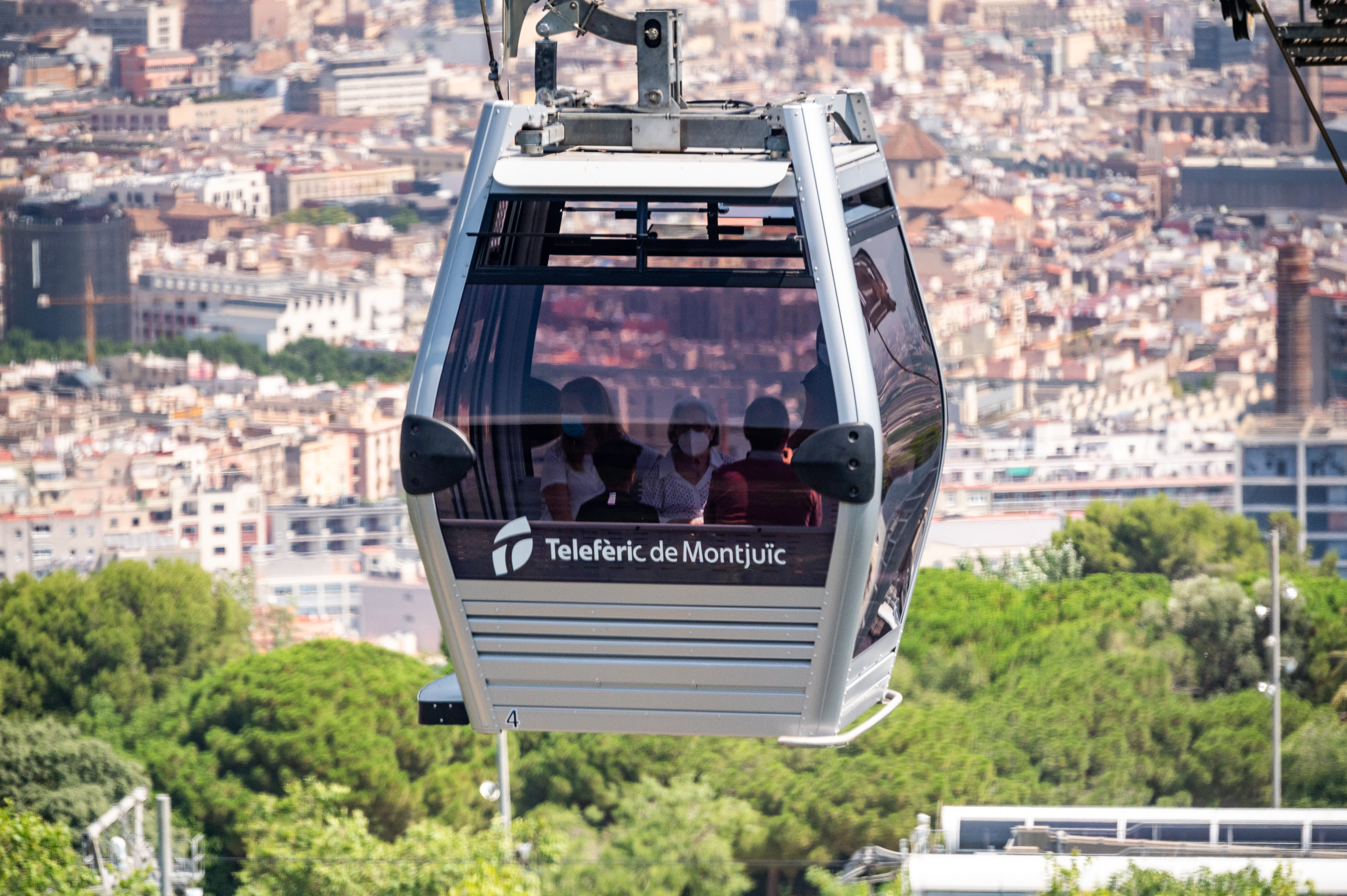 Primer pla d'una cabina del telefèric sobrevolant la ciutat