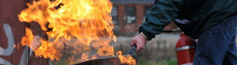 Employee extinguishing fire during fire safety training from Project Skills Solutions