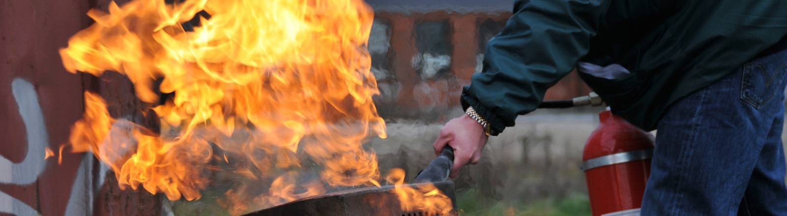 Employee extinguishing fire during fire safety training from Project Skills Solutions