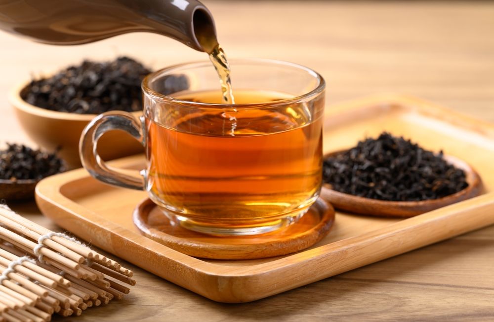 Black,Tea,In,Cup,Glass,With,Teapot,Pouring,Tea,,Healthy