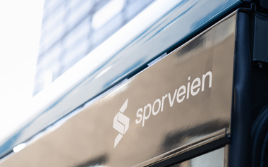 Sporveien logo på trikk i blålig lys