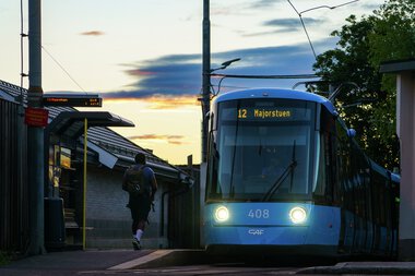 Reisende går mot SL18 i solnedgang på Kjelsås