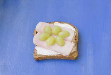 Skive med kalkunpålegg, kremost og druer