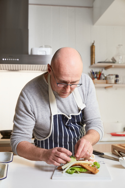 Ole Martin Alfsen monterer sine  smørrebrød med panert fisk og reker