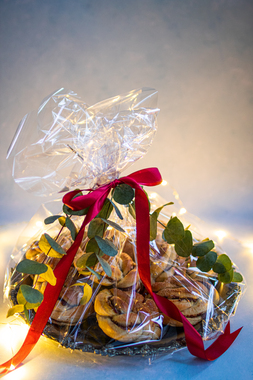 Til familien som er i koronaisolasjon og trenger en oppmuntring: Søte kanelknuter på fat med cellofan, rødt silkebånd og eukalyptuskvister