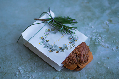 Til den som bare tenker på andre og glemmer seg selv i juleforberedelsene: Energirik og fruktig müslirundstykke med brunost i liten gavepose med juletrykk.