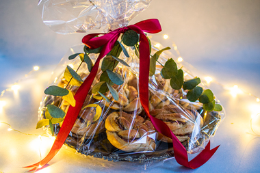 Til familien som er i korona -isolasjon og trenger en oppmuntring: Søte kanelknuter på fat med cellofan, rødt silkebånd og eukalyptuskvister.