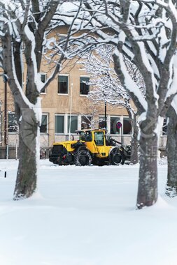 Gravemaskin brøyter snø i sentrum