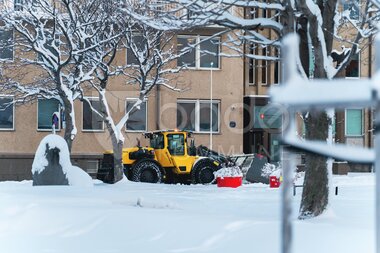 Gravemaskin brøyter snø i sentrum