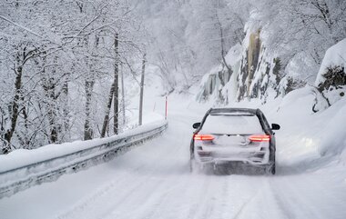 Bil på veg i vinterlandskap